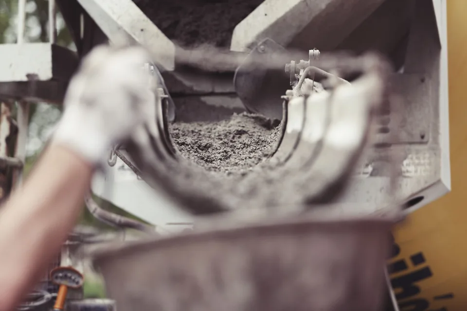 Fresh concrete being delivered from a mixer chute
